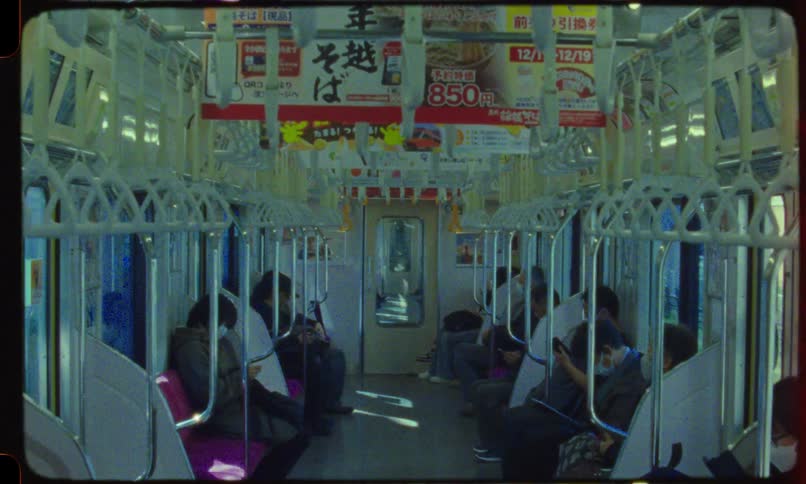 Vintage film captures the quiet commute of passengers on a sunlit Japanese train car