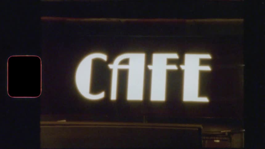 Dreamy vintage Super 8 footage of a bustling Parisian cafe at night with glowing neon signs
