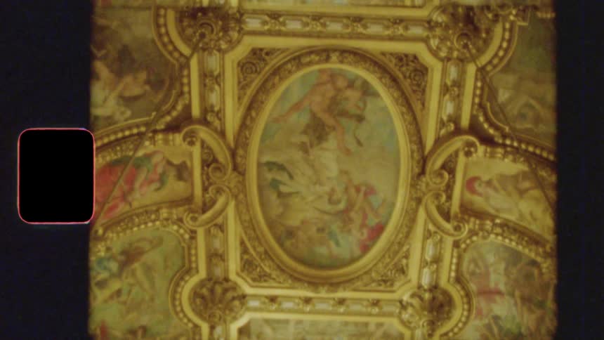 Vintage 8mm footage slowly reveals the stunningly ornate and gilded interior of a grand European opera house ballroom