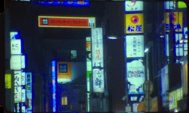 Vintage 8mm film captures the colorful glowing neon signs and advertisements on a busy street in Tokyo, Japan at night