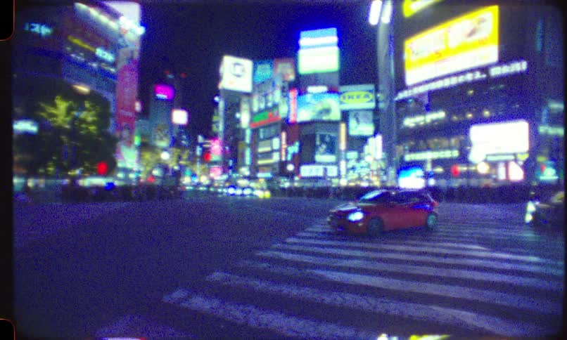 Dreamlike Super 8 film captures the vibrant neon signs and traffic at Shibuya Crossing, Tokyo