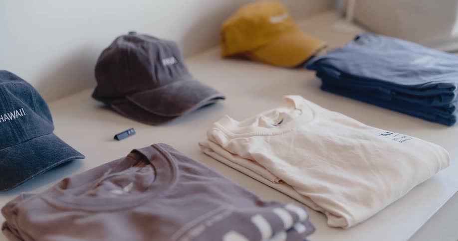 A slow zoom reveals a trendy display of branded t-shirts and hats in a minimalist clothing boutique