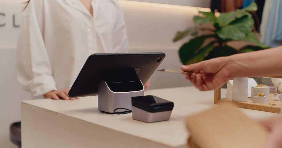 A customer makes a purchase by inserting their credit card into a payment terminal at a checkout counter