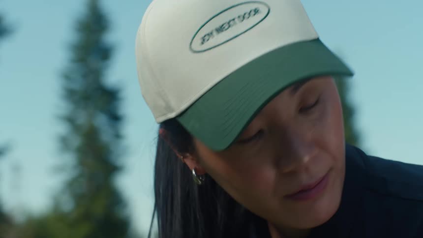 A close-up slow-motion shot of a focused woman wearing a baseball cap while playing golf on a sunny day