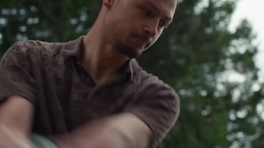 Close-up slow motion shot of a young man concentrating and swinging a golf club outdoors