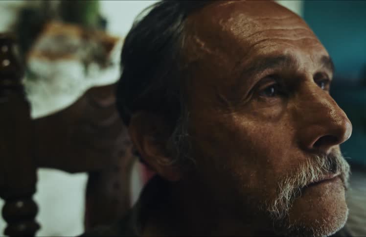 Close-up shot of a pensive senior man slowly opening his eyes while deep in thought