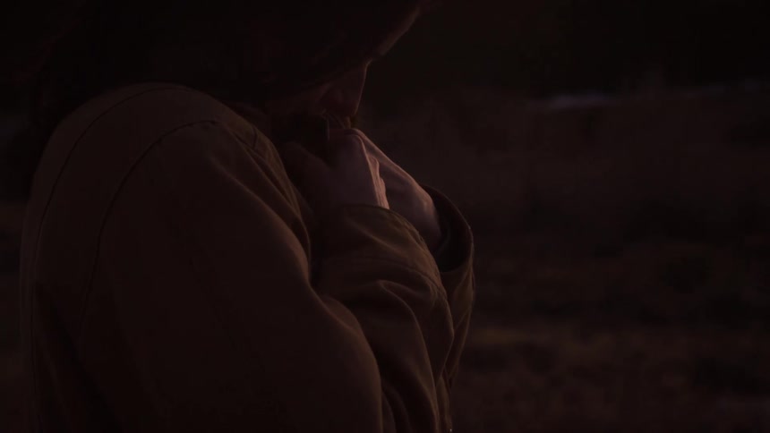Close up on a woman in profile as her happy expression turns sad while standing alone at sunset