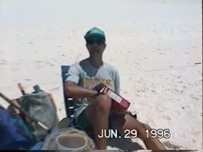 A father and his two children relax on the beach while snacking on Cheez-Its in this authentic 1996 home video