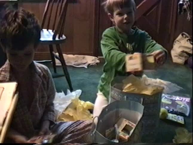Two young brothers in their pajamas excitedly open Easter baskets full of toys and candy