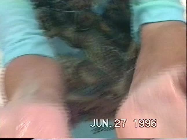 A young boy on a family beach vacation in 1996 plays in the waves before finding a small sea bug and excitedly showing it off to the camera