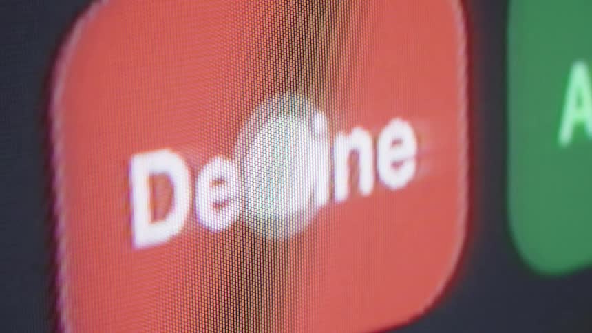 A close-up shot of a smartphone screen shows a finger touching the red decline button to reject an incoming call