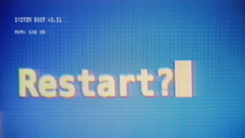 A vintage computer screen with a blue background displays a pixelated 'Restart?' prompt with a blinking cursor before glitching out