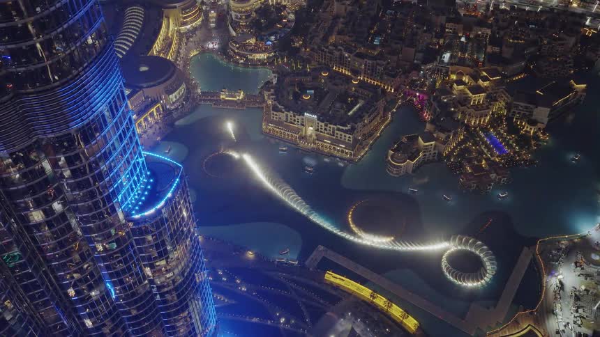 An incredible birds-eye view from the Burj Khalifa shows the dazzling Dubai Fountain show illuminating the city at night
