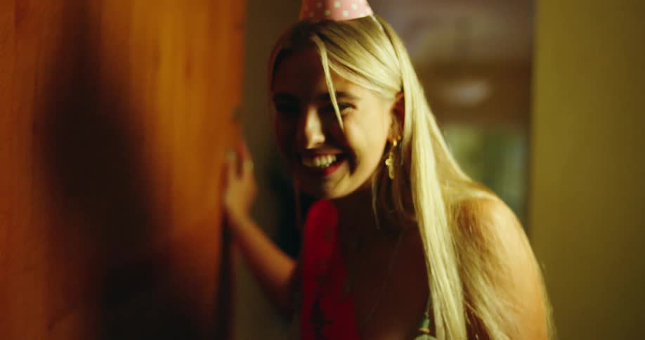 From a POV perspective, a woman celebrating her birthday opens the door, her expression shifting from disappointment to surprise and excitement as she receives a pair of handcuffs