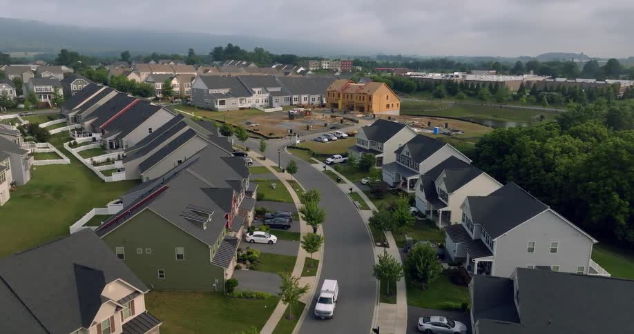 An aerial view of a quiet suburban neighborhood with new houses under construction on an overcast day