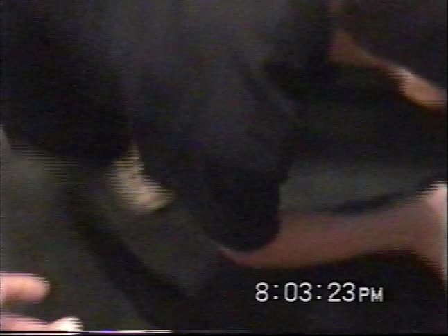 Candid home video captures a young boy in a baseball cap lovingly petting his black dog