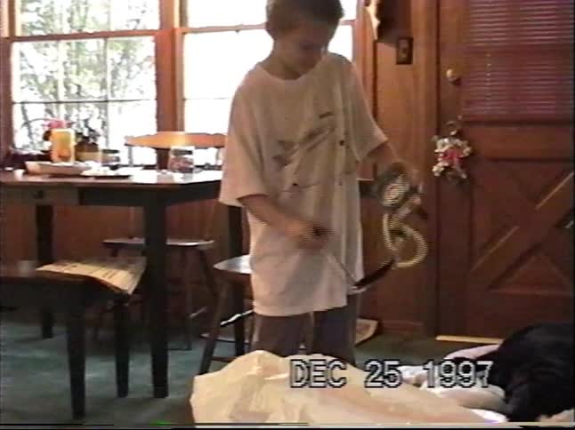 Nostalgic home video from Christmas morning 1997 shows a young boy unwrapping and playing with a new toy