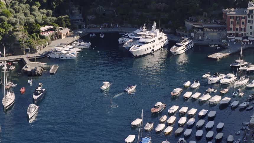 A stunning aerial view captures the picturesque harbor of Portofino, Italy, teeming with luxury yachts and sailboats