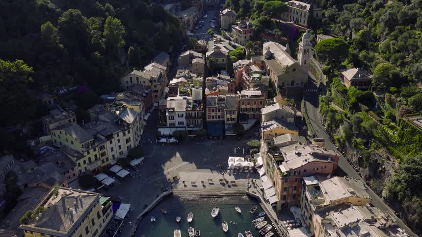 An aerial view reveals the picturesque Italian fishing village of Portofino, with its colorful buildings surrounding the harbor filled with boats