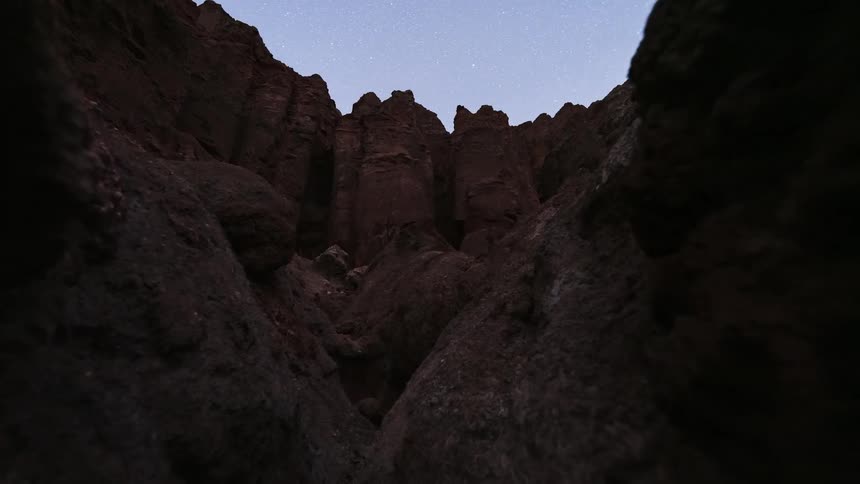 A breathtaking night-to-day timelapse shows the Milky Way galaxy moving across the sky as seen from inside a deep red rock canyon until sunrise