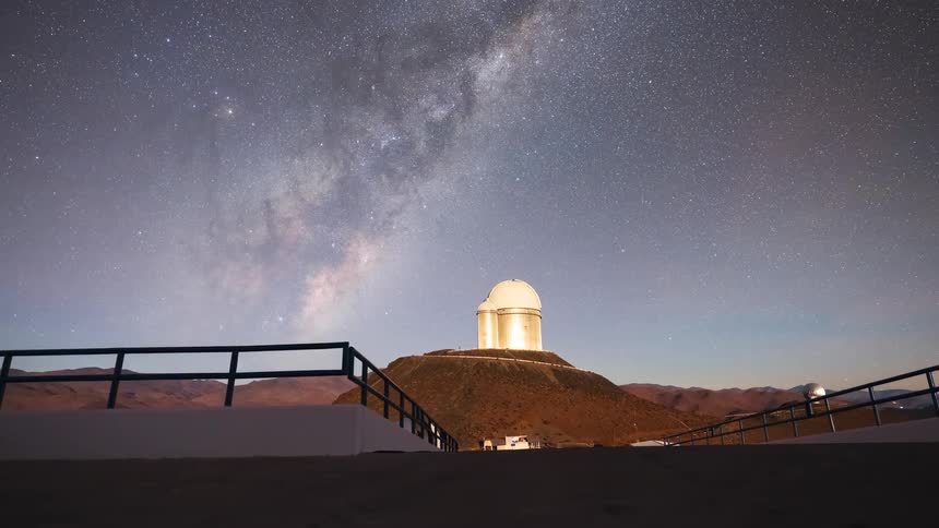 A stunning timelapse reveals the vibrant Milky Way galaxy rising in the night sky over a remote mountaintop astronomical observatory