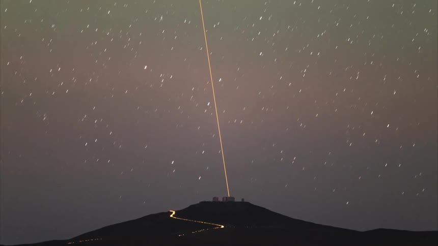 A stunning time-lapse captures the transition from a star-filled night to a vibrant desert sunrise over a mountain top observatory