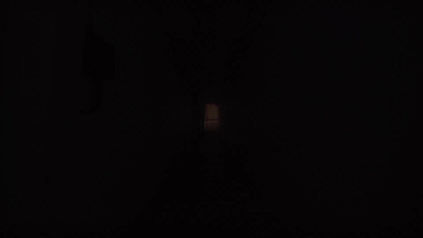 A long, dark hallway with lights that flicker on and off, creating an eerie and unsettling effect