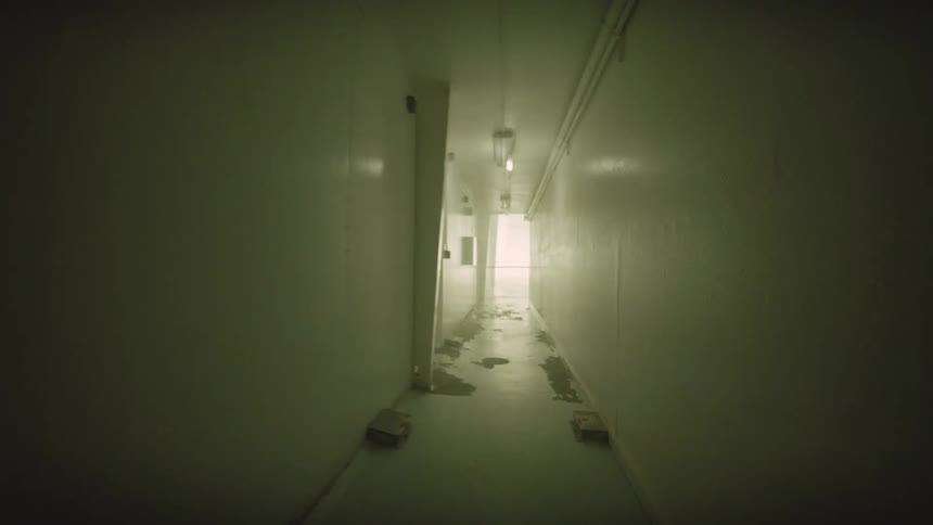 Eerie point-of-view shot progresses through a dark, derelict corridor with strobing lights and a mysterious light at the end