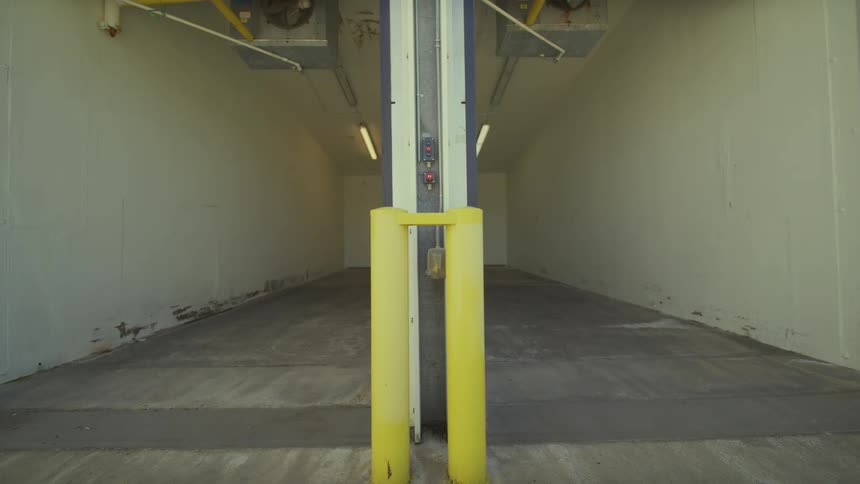 A static, symmetrical view down an empty industrial loading dock or warehouse bay