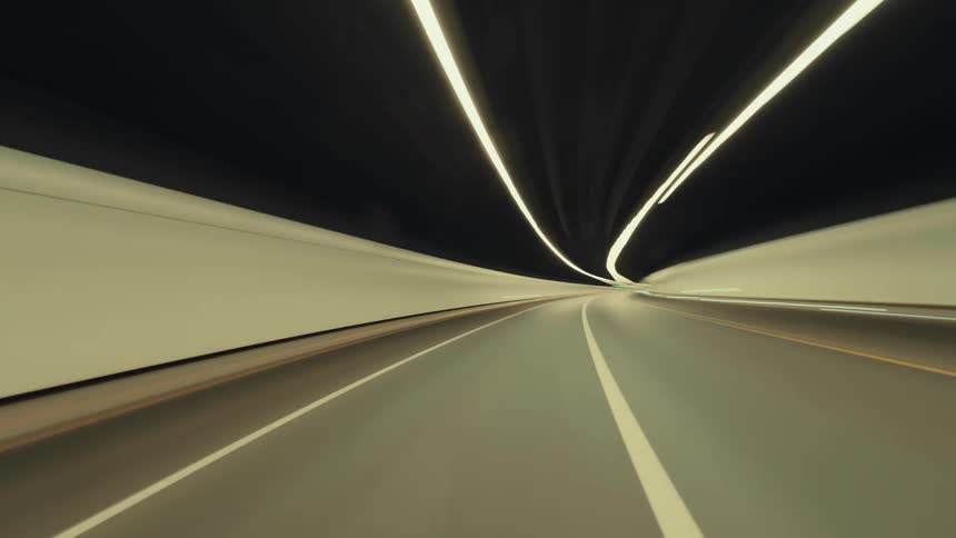 A futuristic time-lapse from the driver's perspective speeding through a modern, illuminated highway tunnel at night
