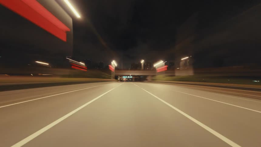 A dynamic hyper-lapse captures a thrilling POV drive down an empty city highway at night, with mesmerizing light trails streaking across the screen