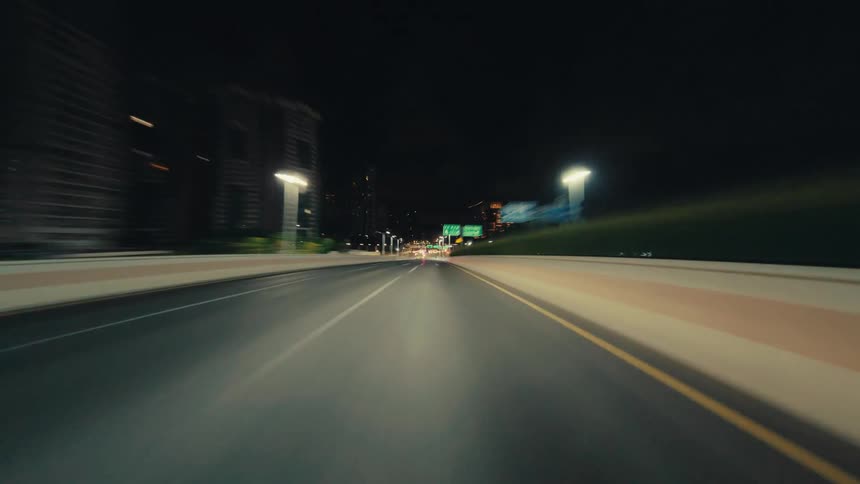 Futuristic hyperlapse POV drive through a gleaming city at night, entering a brightly illuminated tunnel at warp speed