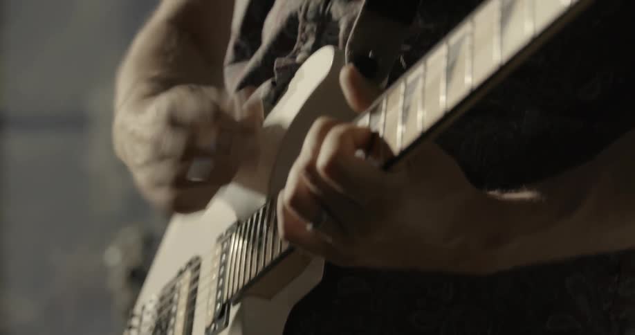 A man strums a guitar