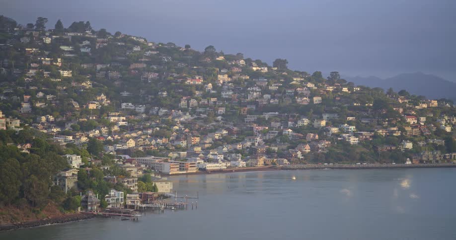 A slow zoom-in shot of the picturesque coastal town of Sausalito, California, nestled on a hillside overlooking the bay