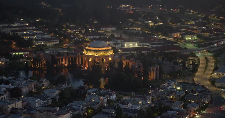 A beautiful aerial shot slowly pushes in on the illuminated Palace of Fine Arts in San Francisco at night