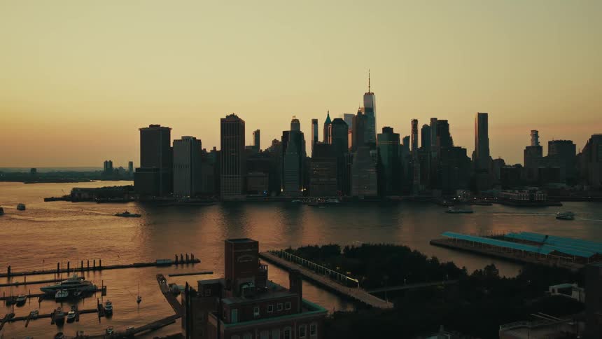 An aerial view of the iconic New York City skyline and the East River during a breathtaking golden sunset