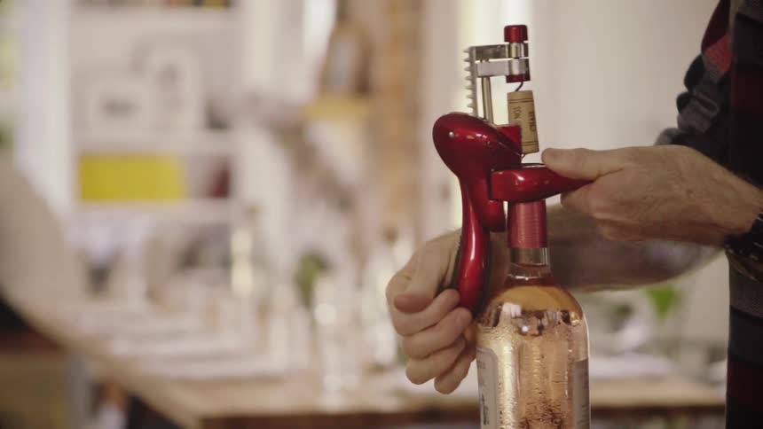 A person opens up a bottle of wine