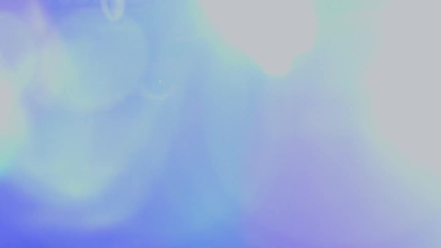 A soft-focus, extreme close-up of a person's eye revealed through vibrant, shifting lens flares