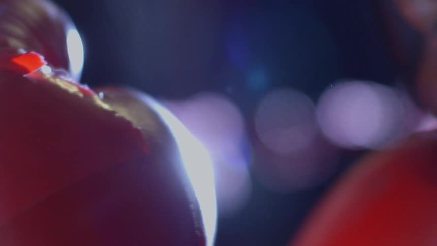 A red balloon expands and explodes in a dramatic slow-motion close-up