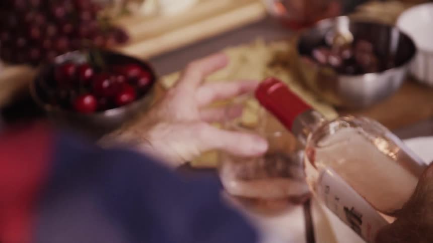 A person pours some wine in a glass