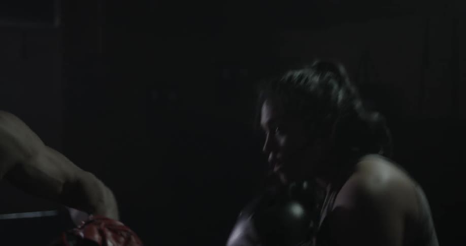 A man sparring with someone inside a building
