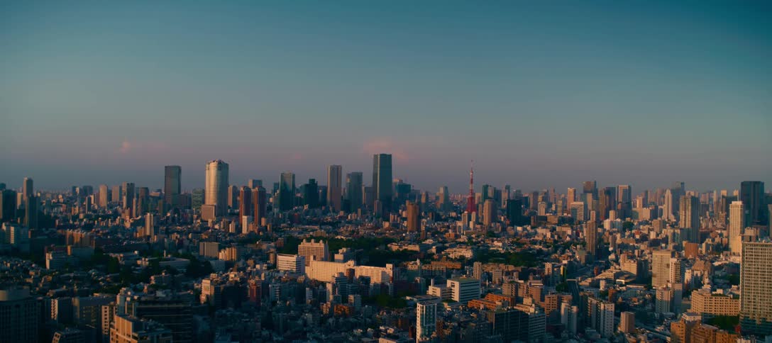 A majestic, wide establishing shot of the Tokyo, Japan skyline with the Tokyo Tower visible during a beautiful sunrise