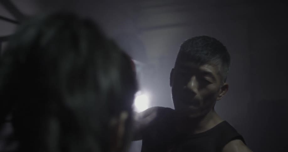 A woman spars with a man using boxing gloves
