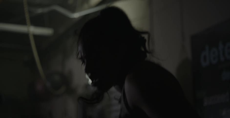 A female athlete is shadow boxing in a gym