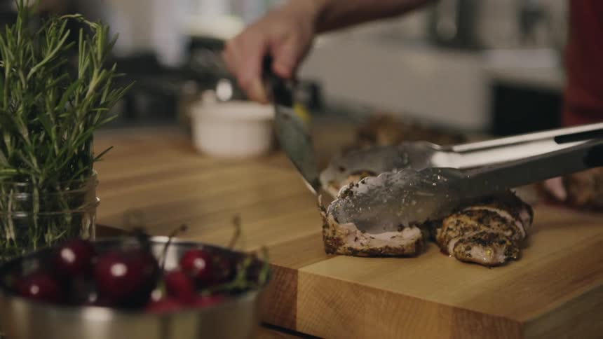 A person serves some meat on a cutting board