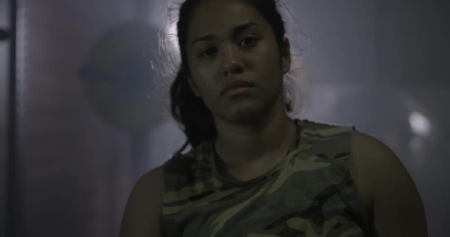 A woman staring at the camera inside a gym