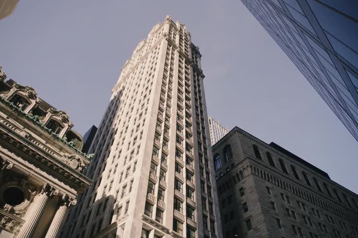 A majestic low-angle view of the historic Woolworth Building skyscraper reaching towards a clear sky in downtown New York City