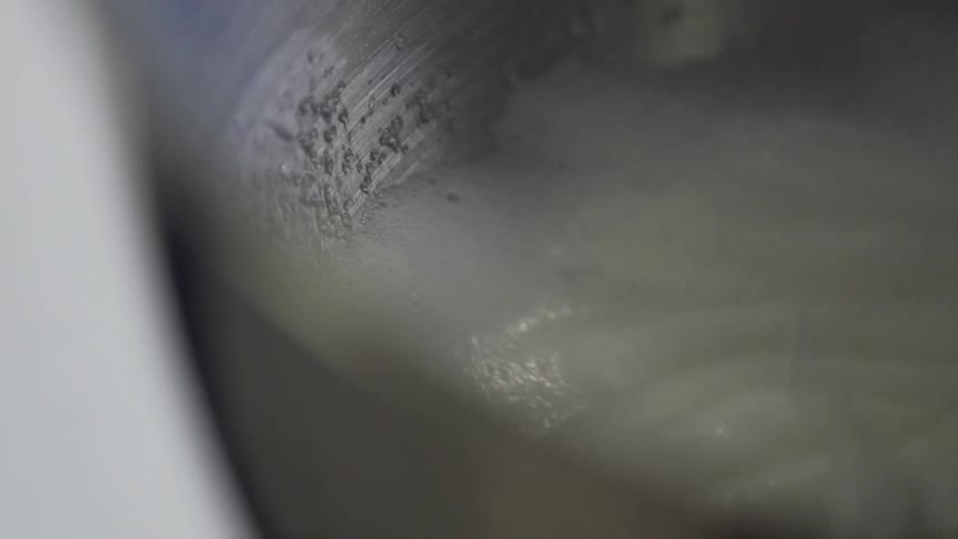 A mixer is turning batter in a bowl