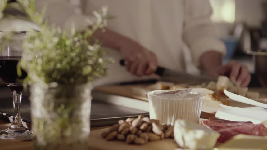 A chef is slicing bread into cubes in a kitchen