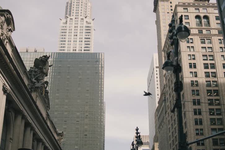 A slow upward tilt reveals the iconic Chrysler Building towering over Vanderbilt Avenue next to Grand Central Terminal in New York City